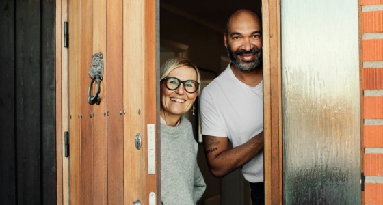 Et par smiler i d&oslash;r&aring;pningen til hjemmet sitt og &oslash;nsker velkommen.